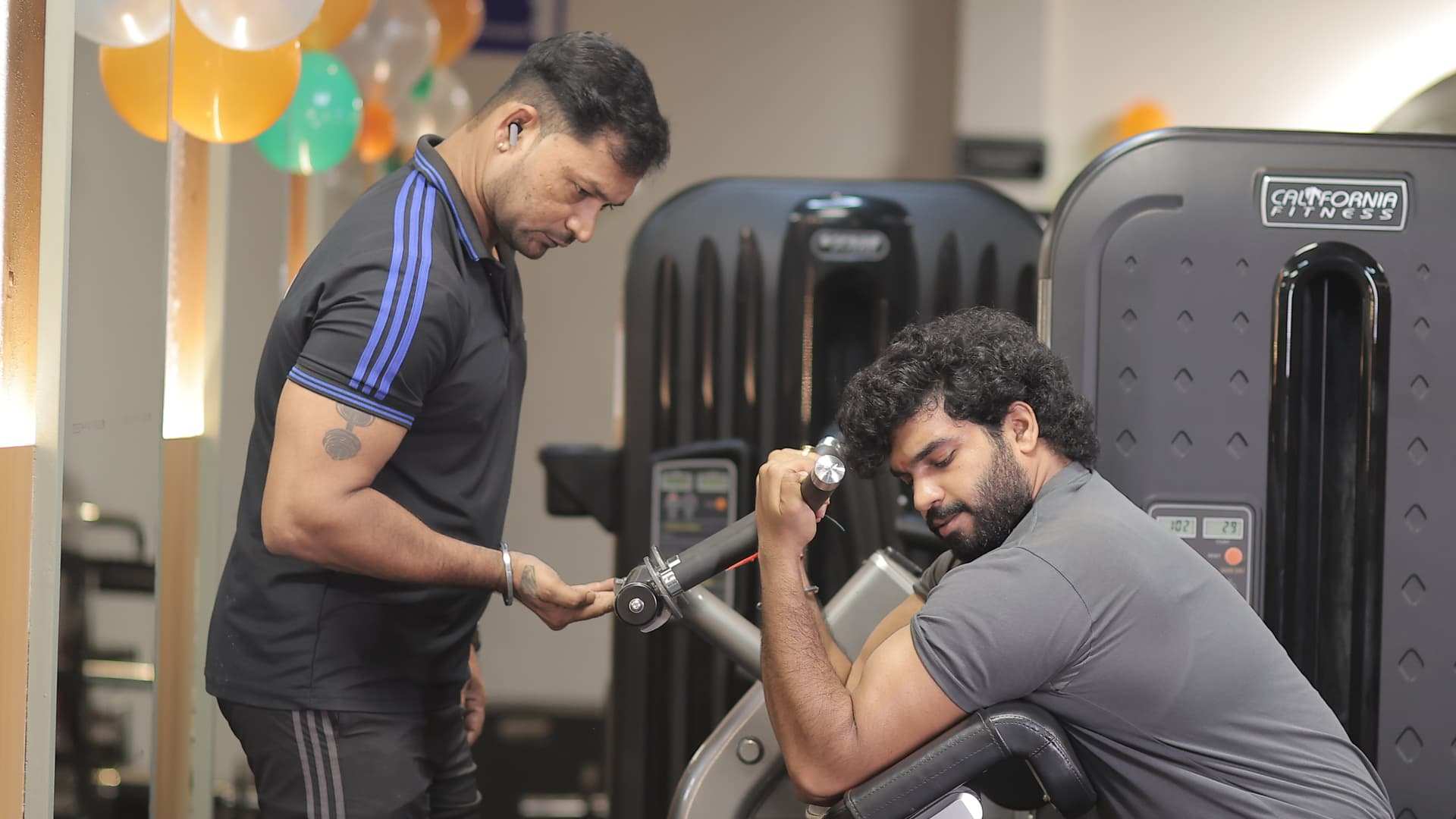A Bludgeon coach setting a member up on a training machine