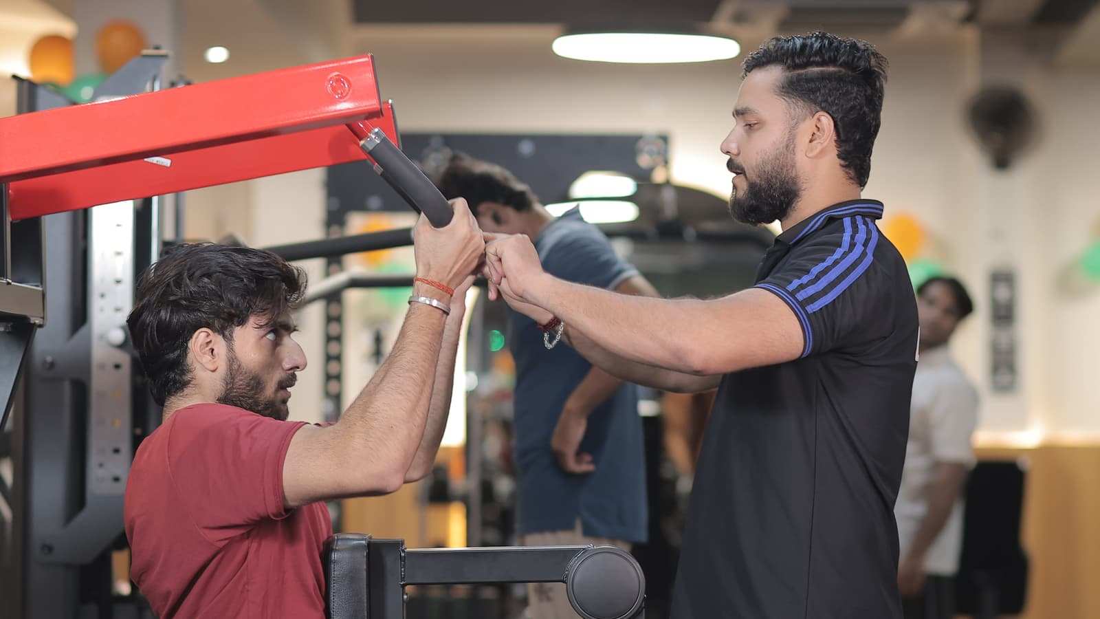 Coach correcting a member's overhead grip on the rig